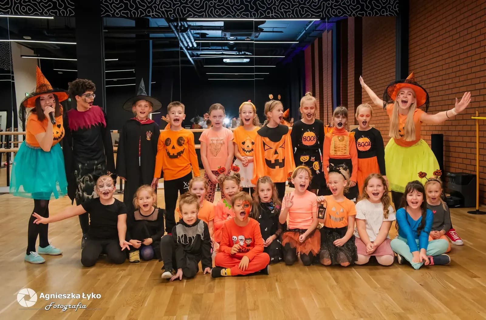 Grupowe zdjęcie dzieci w strojach na balu w sali widowiskowej