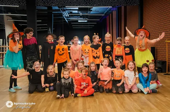 Grupowe zdjęcie dzieci w strojach na balu w sali widowiskowej