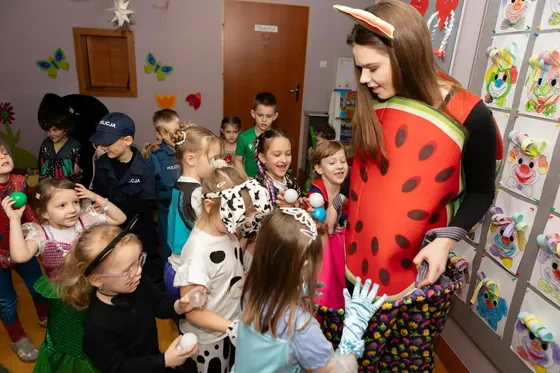 Animatorka w kostiumie z grupą dzieci w strojach karnawałowych
